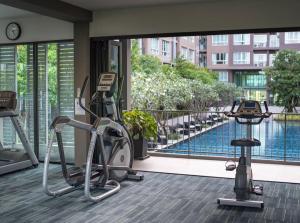 a gym with a view of a pool in a building at Valley Mountain View&City Proximity Golden Eight Apartment in Ban Phlu Yai