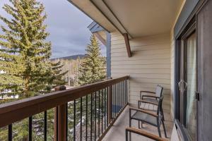 布雷肯里奇Mountain View Penthouse Condo with Loft, Pool, and Hot Tub的阳台配有两把椅子和一棵树