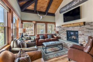 布雷肯里奇Mountain View Penthouse Condo with Loft, Pool, and Hot Tub的配有皮革家具和壁炉的客厅