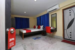 OYO Hotel O Maa Tara Guest House في Jādabpur: غرفة نوم بها سرير ومكتب ومرآة +18 صورة