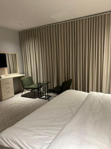 een hotelkamer met een bed, een tafel en stoelen bij Bunyan Alula Hotel in Al Ula