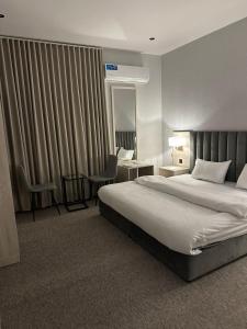 een hotelkamer met een bed en een bureau bij Bunyan Alula Hotel in Al Ula