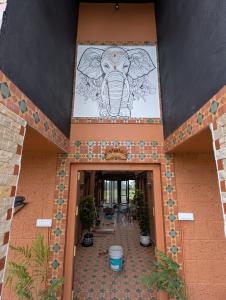 an entrance to a building with an elephant on the wall at Aura Kabini by Tripture in Begūr +11 photos