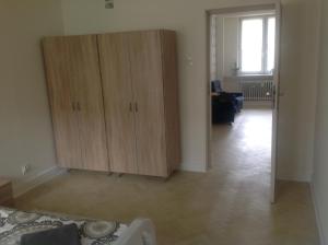 Habitación con armario de madera y sala de estar. en Nordic Apartamenty Lipowa, en Białystok