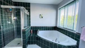 un bagno piastrellato verde con vasca e doccia di Warm house a Coquitlam