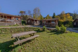 RoquefeuilChalet Montana 4 pers的几间小木屋前草地上的公园长椅