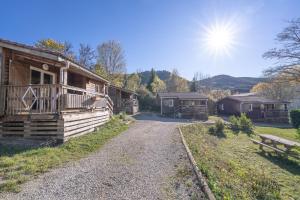 RoquefeuilChalet Montana 4 pers的一组小木屋，前面是一条碎石路。 更多12张照片