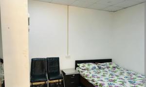Karana guest house的一间卧室配有两张黑色椅子和一张床