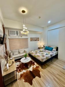 Un dormitorio con una cama y una sala de estar. en J&A Cozy Calm Stay, en Biñan