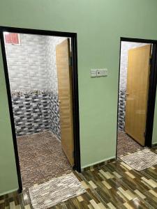 a bathroom with two mirrors and a walk in shower at Inara Homestay in Kepala Batas