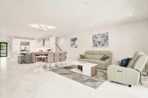 ein Wohnzimmer mit weißen Möbeln und ein Esszimmer in der Unterkunft New 4BR w Pool Walk to Las Olas 5mins to Beach in Fort Lauderdale