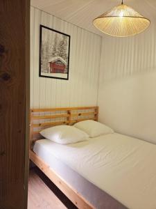1 dormitorio con cama y lámpara en L'Epicéa - Logement Nature, en Mijoux