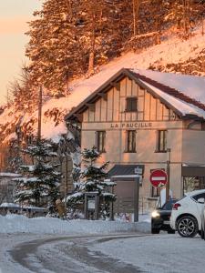un coche aparcado frente a un edificio en la nieve en L'Epicéa - Logement Nature, en Mijoux