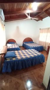 Dos camas en una habitación con sábanas azules y techos de madera. en Hotel El Paraje, en Santa Cruz 20 fotos más