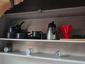 uno scaffale con un mucchio di pentole e padelle di Doce lar a Serra