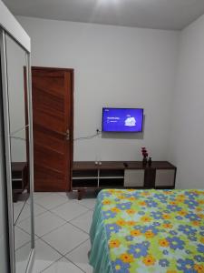 una camera da letto con un letto e una TV a parete di Doce lar a Serra