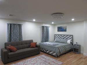 a bedroom with a bed and a couch at Cozy Rooms in Ozone Park in Brooklyn Manor