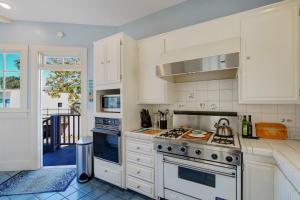 een keuken met witte kasten en een kookplaat oven bij Casa Azzurra in Santa Barbara