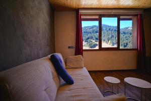 アンドラ・ラ・ベリャにあるAcogedor Rincón de Ski I Paniqueraのソファと大きな窓のあるリビングルーム