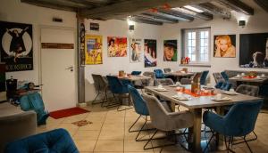 a restaurant with tables and chairs and posters on the walls at Hotel Karthäuser Hof in Flörsheim am Main