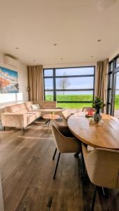 a large living room with a table and a couch at Maison du Lac in Lathum