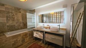 ein Badezimmer mit zwei Waschbecken und einer Badewanne in der Unterkunft Maison familiale rénovée au calme a bon encontre in Bon-Encontre