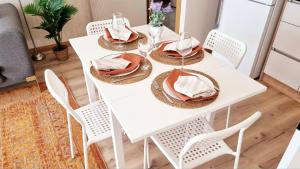 a white dining room table with white chairs and napkins at 2 Bedroom Cozy Apartment in Antalya +22 photos