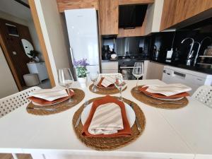 a table with two plates and wine glasses on it at 2 Bedroom Cozy Apartment in Antalya