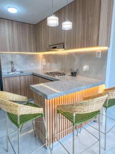 佛罗里达布兰卡Apto moderno con aire y gran ubicación的厨房配有带椅子和炉灶的柜台