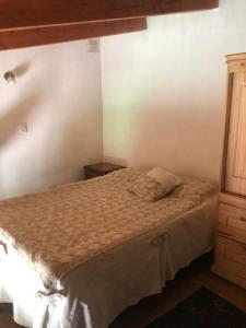 Un dormitorio pequeño con una cama y un armario de madera. en Piltri duplex, en El Bolsón