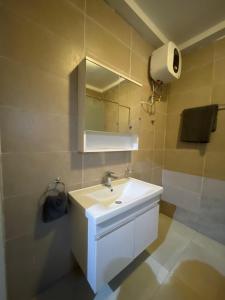 a bathroom with a white sink and a mirror at Noahjoelestate in Accra