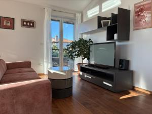 un salon avec un canapé et une télévision à écran plat dans l'établissement House Mia, à Ližnjan