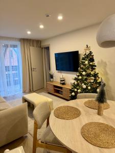 a living room with a christmas tree in front of a television at Nidos Natos in Nida