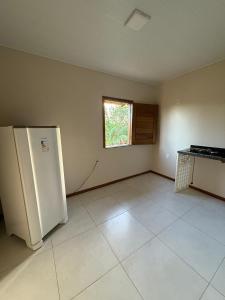 una cocina vacía con un refrigerador y una ventana en Pousada Encantos do Litoral, en Maraú