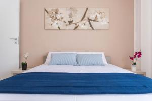 a bedroom with a bed with a blue blanket at Politeama Luxury Suites in Palermo