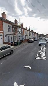 een straat met auto's aan de kant van de weg bij Quiet Nest in Coventry