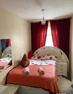 een slaapkamer met een bed en een raam met rode gordijnen bij Quiet Nest in Coventry