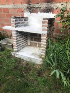 una panca di pietra seduta accanto a un muro di mattoni di Piltri2 monoambiente a El Bolsón