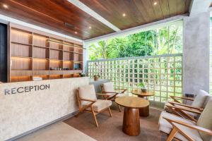 eine Lobby mit Tischen und Stühlen und einem Rezeptionstresen in der Unterkunft MODERN AND COMFORTABLE JUNGLE VISTA HOTEL Ubud Bali By JV with a relaxing atmosphere in Ubud