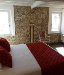 ein Schlafzimmer mit einem Bett und einer Ziegelwand in der Unterkunft The column of Campo de' Fiori in Rom