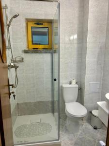 a bathroom with a toilet and a glass shower at Montana Inn Slănic Moldova in Slănic-Moldova
