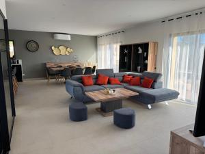 un soggiorno con un divano e un tavolo di Casa Nostra Villa Récente Climatisée - Piscine Chauffée a Lecci