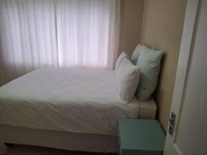 谢普斯敦港The Royal Holiday Home的一张带白色床单和枕头的床以及窗户 更多1张照片