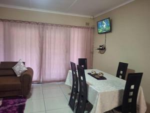 谢普斯敦港The Royal Holiday Home的带桌子和电视的餐厅