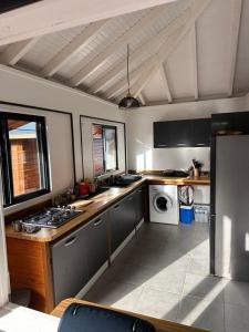 Location saisonnière في بيتي-بور: مطبخ مع حوض وموقد الفرن العلوي