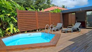 Location saisonnière في بيتي-بور: حوض استحمام ساخن على سطح السفينة مع سياج خشبي