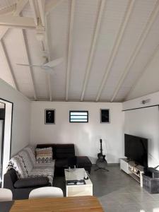 Location saisonnière في بيتي-بور: غرفة معيشة مع أريكة وتلفزيون بشاشة مسطحة +5 صور