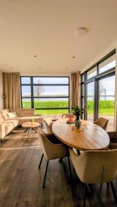 a living room with a table and chairs and a couch at Maison du Lac in Lathum