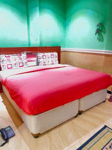 Cama grande en habitación con manta roja en Essérè Mabia hôtel E-M, en Brazzaville 10 fotos más
