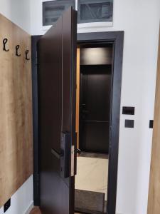 eine offene Tür, die in ein Badezimmer mit einer Tür führt in der Unterkunft New Apartment Moderna SPA&FUN Zlatibor Centar in Zlatibor
